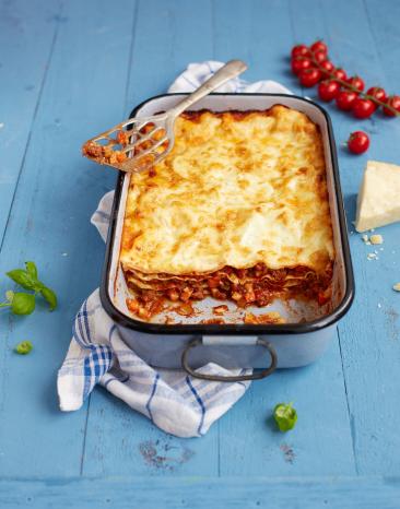 Lasagne bolognese angeschnitten in einer Auflaufform. Lasagne bolognese angeschnitten in einer Auflaufform.