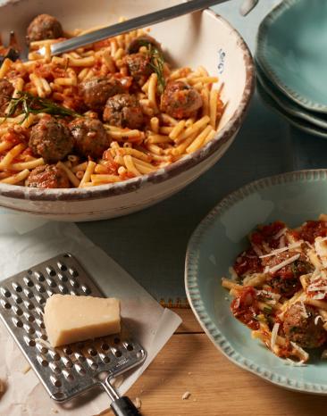 Makkaroni mit Tomaten-Hackbällchen-Sauce in einem Teller und einer Schale.