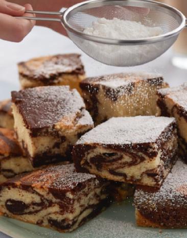 Marmorkuchen in mehreren Stücken wird mit Puderzucker bestäubt.