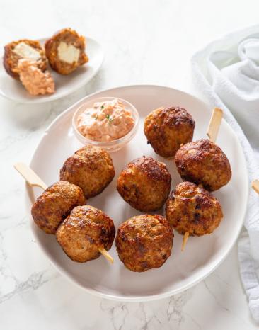 Mediterran gefüllte Hackbällchen auf einem Teller mit Dip