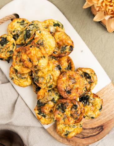 Mini Speck und Ei Frittatas auf einem Brett gestapelt.