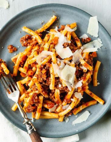 Pasta Bolognese auf Teller mit Parmesan und Basilikum garniert Pasta Bolognese auf Teller mit Parmesan und Basilikum garniert