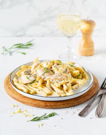 Pasta auf Teller mit Hähnchen in Sahne-Weißweinsauce