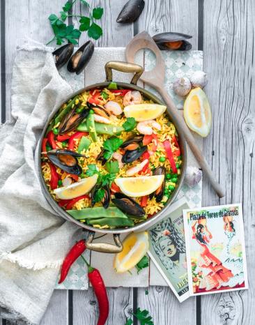 Pfanne mit bunter Paella, Gemüse und Meeresfrüchten.