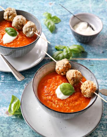 Paprika-Reis-Suppe und Hackbällchen in einer Suppenschale.