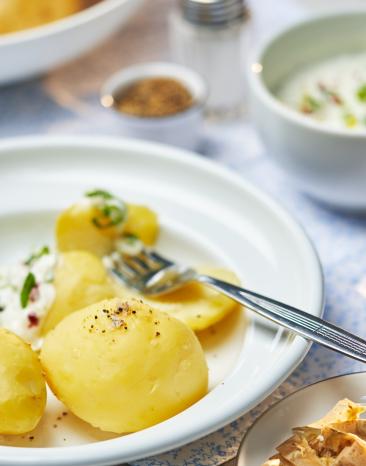 Pellkartoffeln auf einem Teller mit Petersilie garniert.