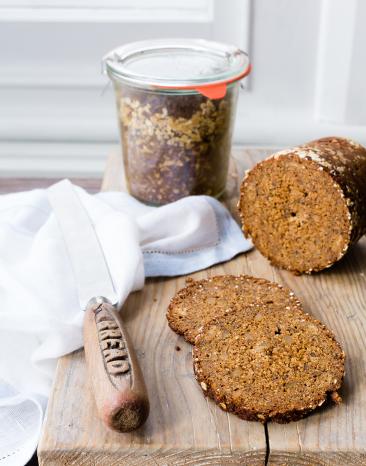 Pumpernickel im Glas, daneben ein Brot in Scheiben geschnitten. Pumpernickel im Glas, daneben ein Brot in Scheiben geschnitten.