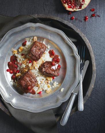 Rehmedaillons mit Risotto und Granatapfel auf Teller