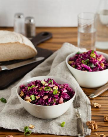 Zwei Schalen mit Rotkohlsalat auf Holztisch.