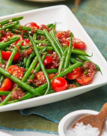 Salat von grünen Bohnen mit Balsamico-Schalotten und Kirschtomaten auf einem Teller. Salat von grünen Bohnen mit Balsamico-Schalotten und Kirschtomaten auf einem Teller.