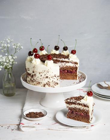 Torte auf Tortenplatte mit Vase und Kuchenstück auf Teller Torte auf Tortenplatte mit Vase und Kuchenstück auf Teller
