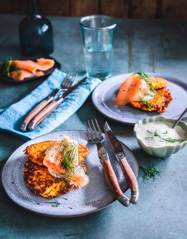 Süßkartoffelpuffer mit Lachstopping auf einem Teller.