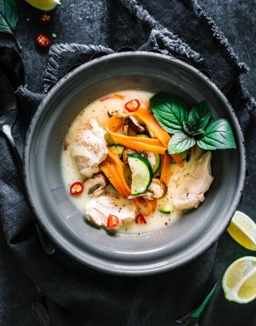 Kokossuppe mit Hühnchen in einer Schüssel. Kokossuppe mit Hühnchen in einer Schüssel.