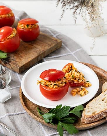 Tomaten gedämpft mit Reisfüllung auf einem Teller mit Brot.