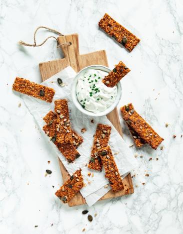 Mehrere Tomaten-Karotten-Cracker mit Pesto auf Schiefertafel. Mehrere Tomaten-Karotten-Cracker mit Pesto auf Schiefertafel.