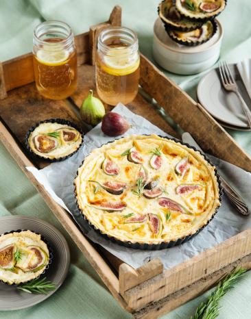 Ziegenkäse-Feigen-Quiche auf einem Holzbrett. 