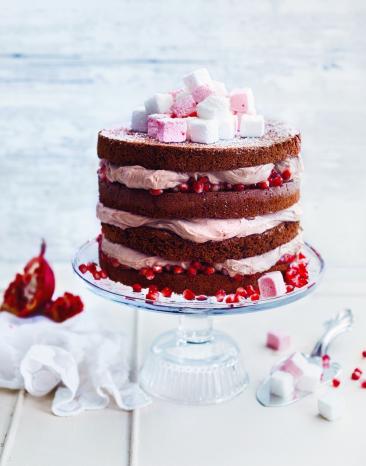 Zimttorte mit Marschmallows und Granatkernen verziert auf Etagere.