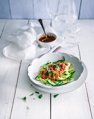 Zucchininudeln auf Teller mit Bolognesesauce Zucchininudeln auf Teller mit Bolognesesauce