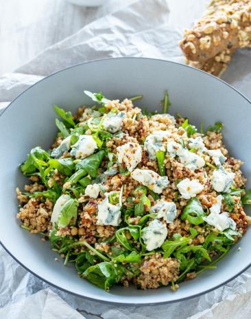 Couscous-Salat mit getrockneten Tomaten im tiefen Teller.