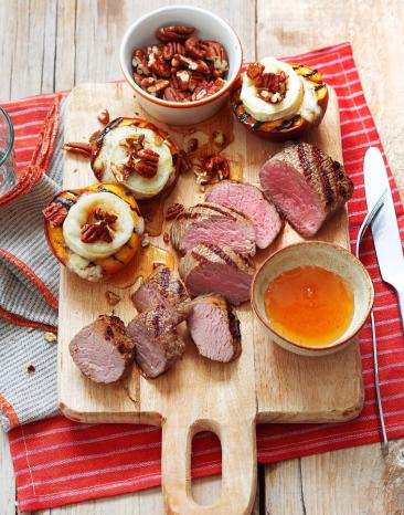 Lammlachs vom Grill mit Ziegenkäse-Nektarinen (Sous-vide) auf einem Holzbrett.