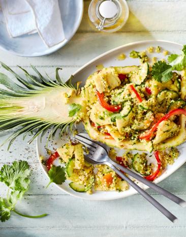 Ananas-Bulgur-Salat in einer halben Ananas angerichtet.