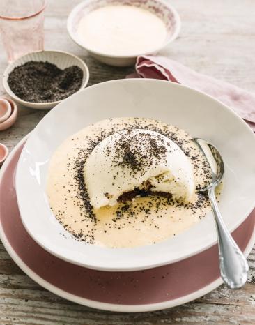 Germknödel mit Vanillesauce im tiefen Teller.