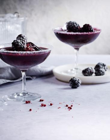 Dunkel roter Drink in einem Cockteilglas mit Beeren. Dunkel roter Drink in einem Cockteilglas mit Beeren.