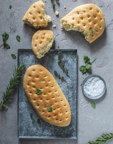 Fladenbrot auf einem Tablett. Daneben steht ein Schälchen mit Meersalz.