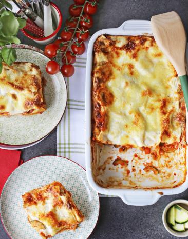 Lasagne in einer Auflaufform und auf einem Teller.