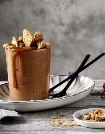 Mousse au Chocolat in zwei Gläsern mit Spekulatiusbröseln garniert.