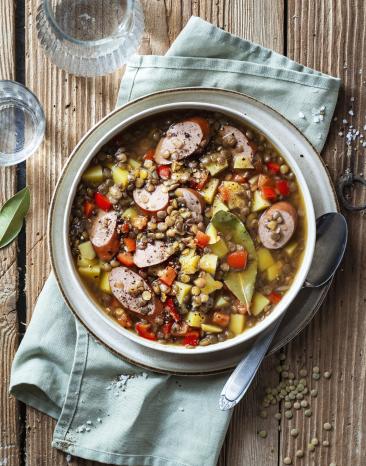 Linseintopf mit Bockwurst in einer Schüssel.