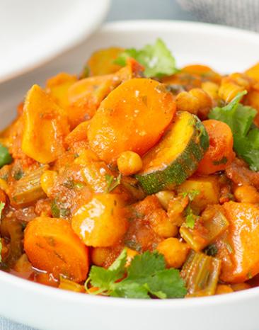 Gemüse-Tajine mit Staudensellerie, Steckrüben, Zucchini, Karotten, Kichererbsen und Couscous.
