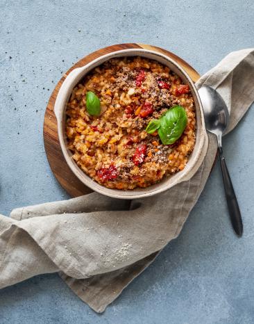 Risotto mit Bolognese und frischem Basilikum.