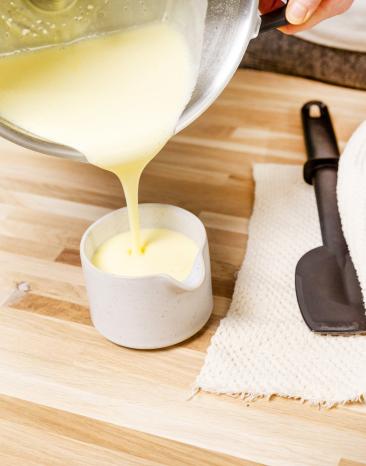 Fertige Sauce Hollandaise wird im letzten Schritt in ein Schälchen gefüllt. Fertige Sauce Hollandaise wird im letzten Schritt in ein Schälchen gefüllt.