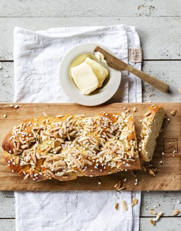 Hefezopf auf Brett mit Schale mit Butter.