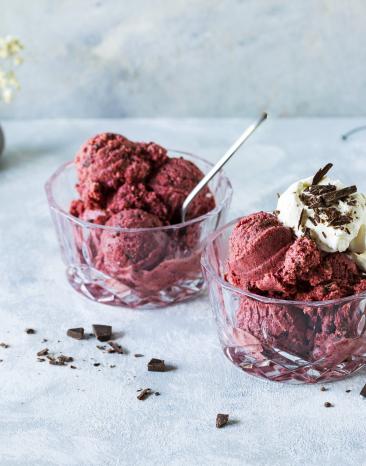 Schwarzwälder-Kirsch-Eis zu Kugeln portioniert serviert in zwei Glasschälchen.