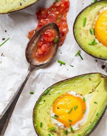 Aufgeschnittene Avocado gefüllt mit Ei aus dem Ofen Aufgeschnittene Avocado gefüllt mit Ei aus dem Ofen