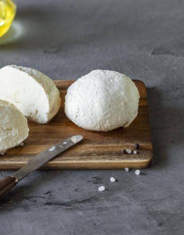 Mozzarellakugel aufgeschnitten auf einem Holzbrett Mozzarellakugel aufgeschnitten auf einem Holzbrett