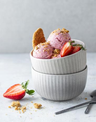 Strawberry-Cheesecake-Eis zu Kugeln portioniert in einer Schüssel. Strawberry-Cheesecake-Eis zu Kugeln portioniert in einer Schüssel.