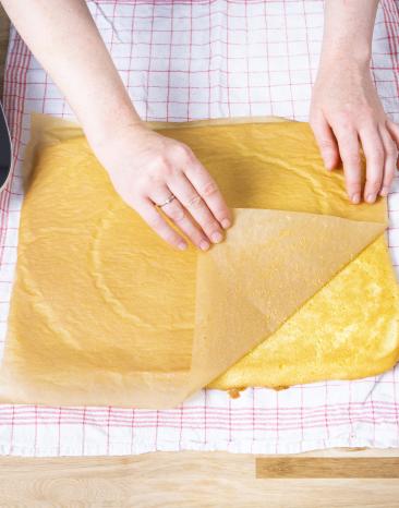 Backpapier wird vom Biskuitteig gelöst. Backpapier wird vom Biskuitteig gelöst.