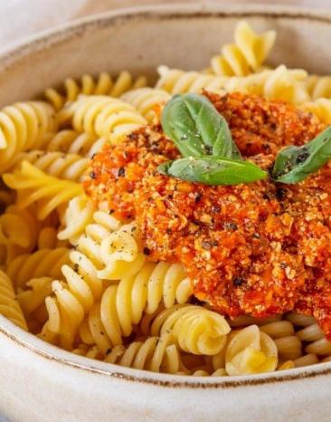 Spirelli-Nudeln mit vegetarischer Bolognese in einer Schale, darauf Basilikum Spirelli-Nudeln mit vegetarischer Bolognese in einer Schale, darauf Basilikum