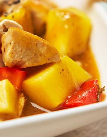 Hähnchen-Curry in Nahaufnahme auf einem eckigen weißen Teller