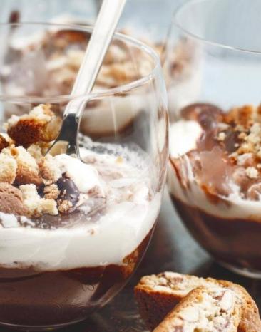 Schichtdessert mit Cantuccinibröseln in drei Gläsern angerichtet auf einem Teller Schichtdessert mit Cantuccinibröseln in drei Gläsern angerichtet auf einem Teller