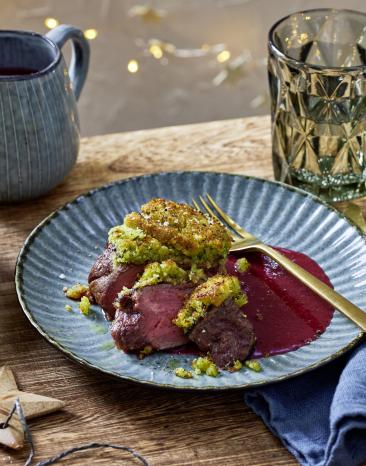 Rinderfilet mit Knusperkruste auf einem roten Soßenspiegel.