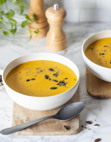 Cremige Kürbissuppe in Schalen garniert mit Kürbiskernen Cremige Kürbissuppe in Schalen garniert mit Kürbiskernen