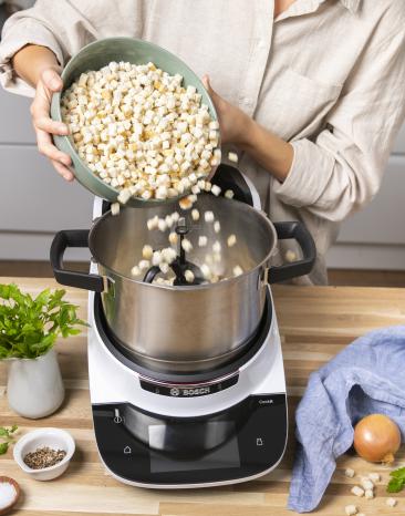Brötchenwürfel werden in den Cookit gegeben. Brötchenwürfel werden in den Cookit gegeben.