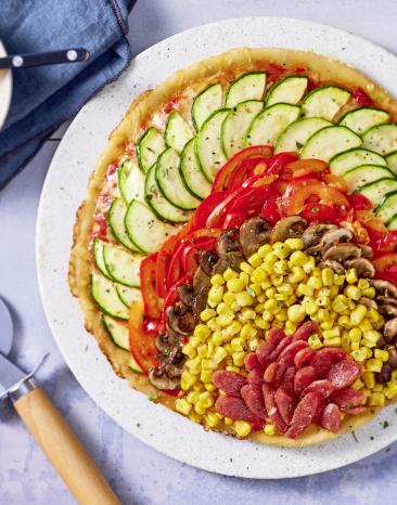 Schnelle Pfannenpizza ohne Hefe belegt mit buntem Gemüse.