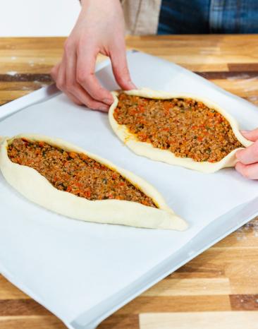 Türkische Pide ist mit Hackfleisch gefülllt und wird zum Schiffchen geformt. Türkische Pide ist mit Hackfleisch gefülllt und wird zum Schiffchen geformt.