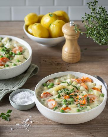 Spargel, Erbsen, Kohlrabi und Karotten in cremiger Sauce in zwei Schälchen.