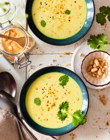 Kokossuppe in grünen Schüssel angerichtet.